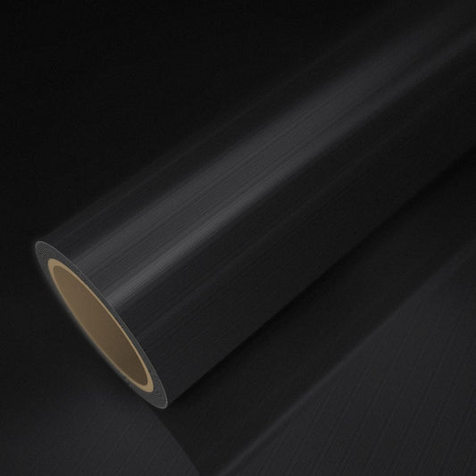 Roll of brushed black vinyl wrap on a sheet of the same vinyl