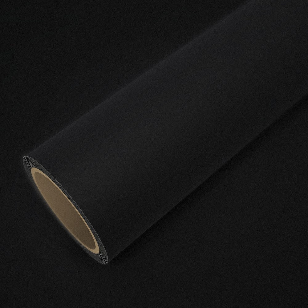 Roll of matte black vinyl wrap on a sheet of the same vinyl