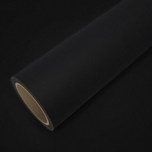Roll of matte black vinyl wrap on a sheet of the same vinyl