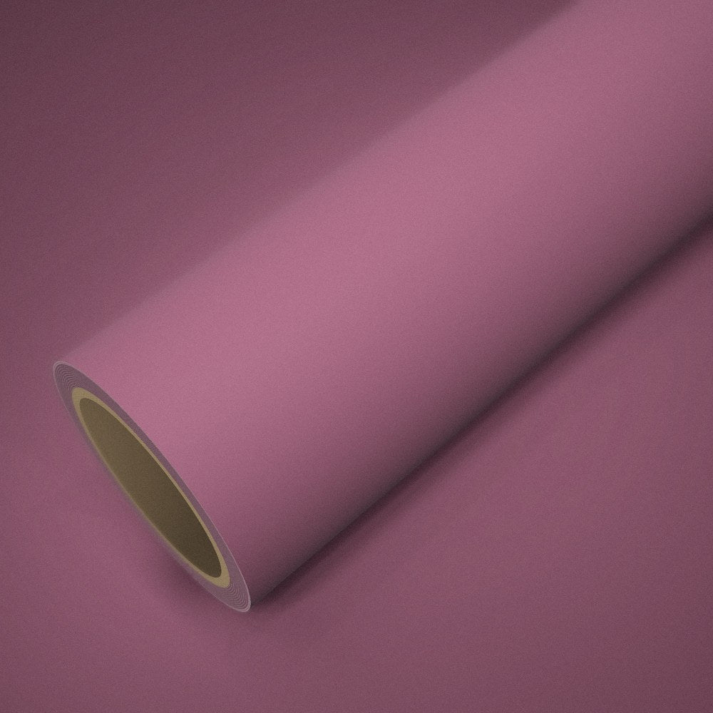 Roll of matte pink vinyl wrap on a sheet of the same vinyl