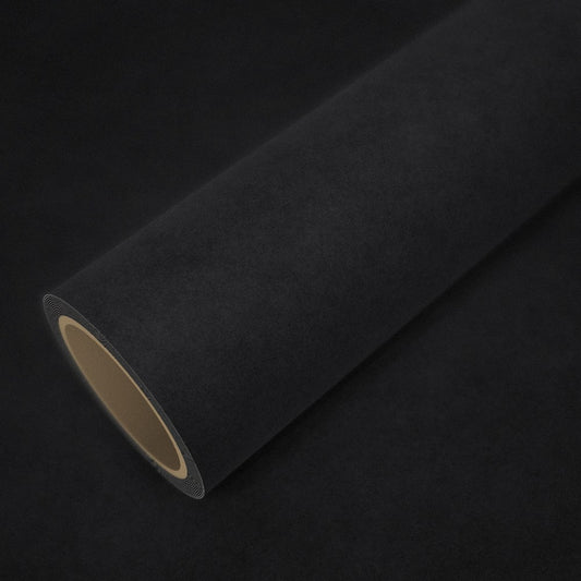 Roll of black alcantara effect vinyl wrap on a sheet of the same vinyl