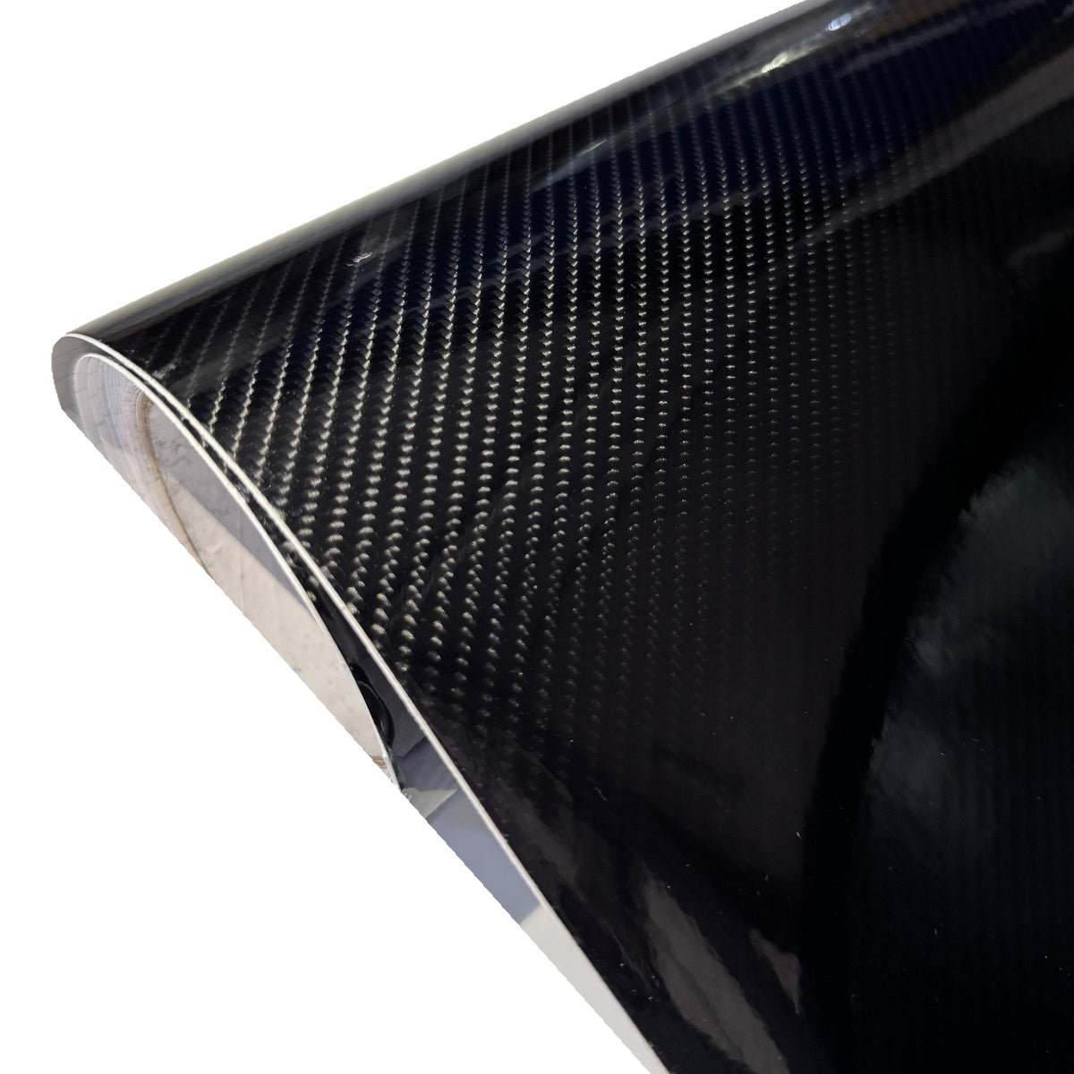 Edge of the roll of Premium gloss black carbon vinyl and carbon weave